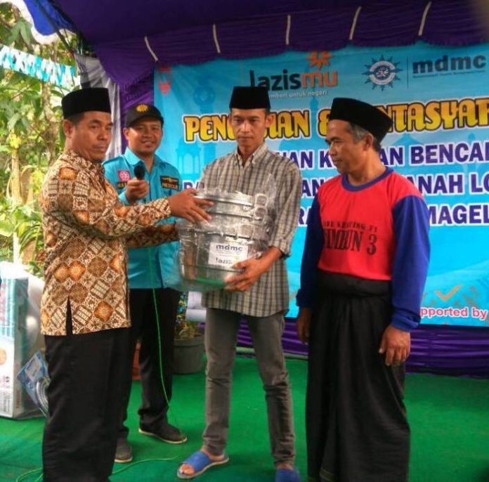 1105-Ketua PD Muhammadiyah Kabupaten Magelang Jumari (paling kiri)menyerahkan bantuan peralatan dapu kepada warga terdampak banjir di Desa Citrosono Kecamatan Grabag