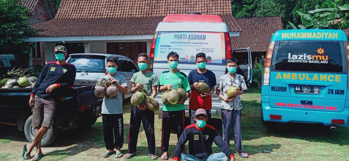 Sejumlah Anak Asuh Panti Asuhan Muhammadiyah Candimulyo Kabupaten Magelang Menunjukkan Buah Kelapa Hasil Panen