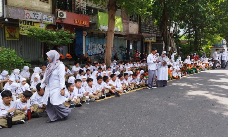 Siswa SD Muhammadiyah 1 Solo memberi penghormatan terakhir PB XIII di Jalan Slamet Riyadi