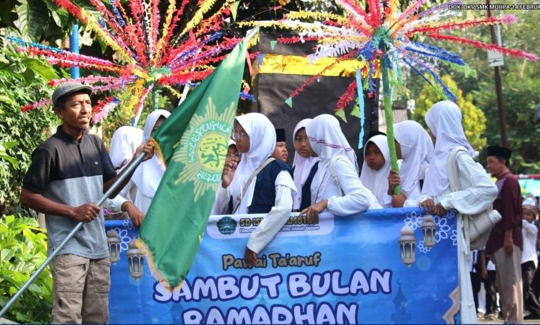 Barisan siswa SD Islam Pamotan membawa bendera Muhammadiyah dan spanduk Pawai Ta’aruf menyambut Awal Puasa Ramadhan 2026 Muhammadiyah.
