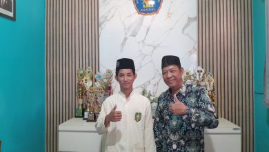 Bagus Satrio Aji, siswa MTs Muhammadiyah 1 Weleri hafal 30 Juz, berfoto bersama Kepala Madrasah Sugiarto di depan deretan piala prestasi.