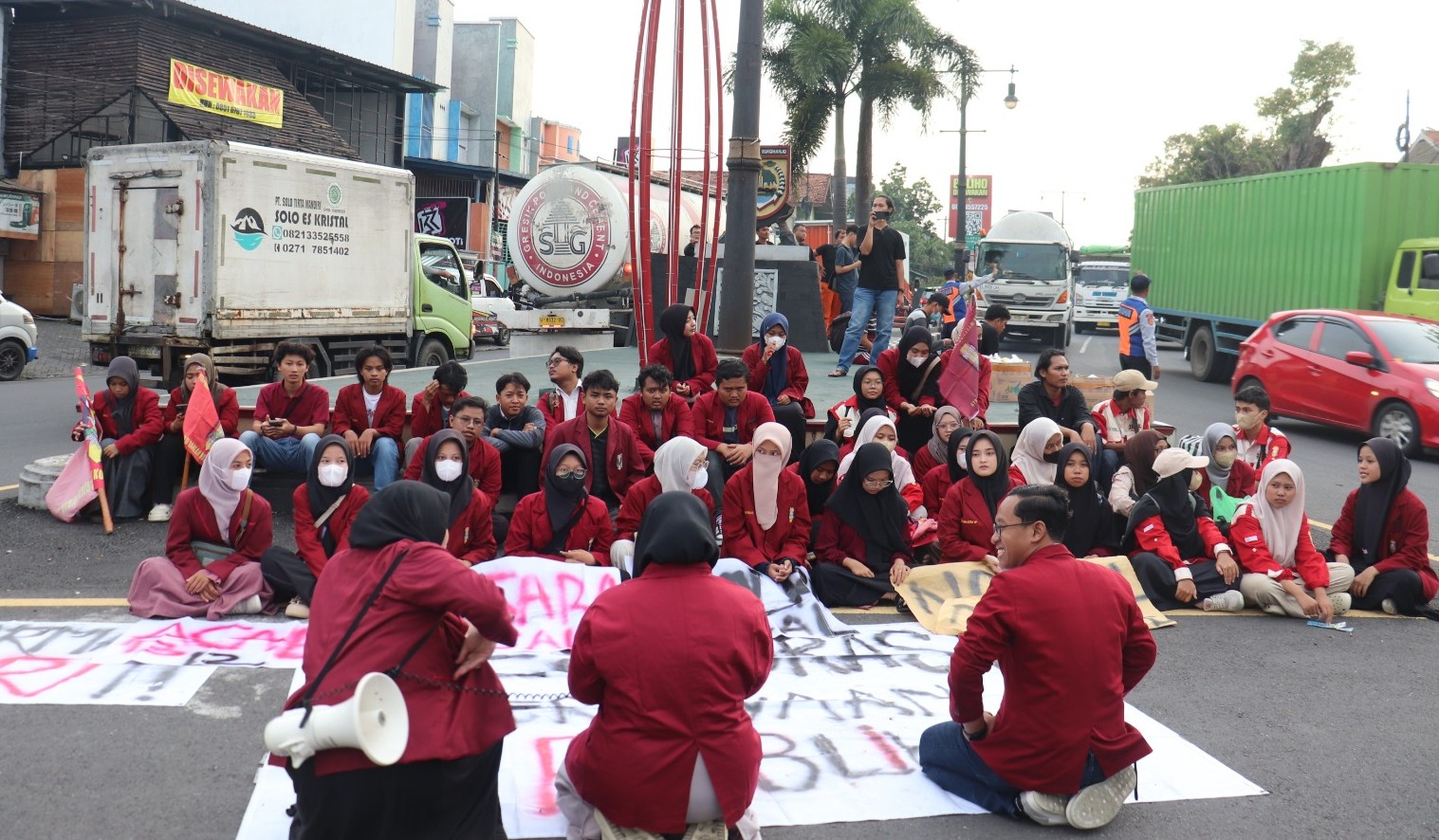 Mahasiswa PC IMM Ahmad Dahlan Kota Surakarta menggelar aksi duduk dan pembagian takjil di Tugu Kartasura saat menyampaikan aspirasi terkait kondisi demokrasi.