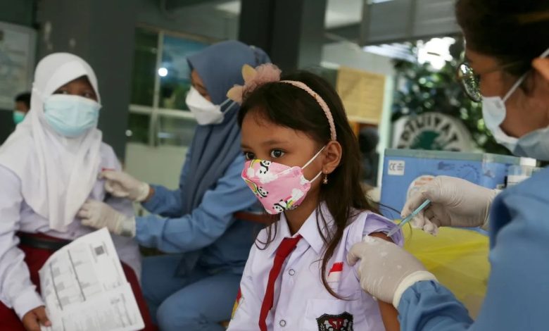 Tenaga kesehatan memberikan vaksin kepada seorang anak sekolah dasar dalam kegiatan imunisasi sebagai upaya melindungi diri dan membentuk kekebalan komunitas.