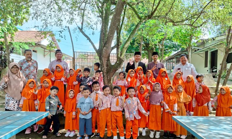 Anak-anak TK Abas Two berfoto bersama pengasuh dan santri di PPMTQ Al Ijtihad Sirau Banyumas dalam kegiatan berbagi infak Ramadan.