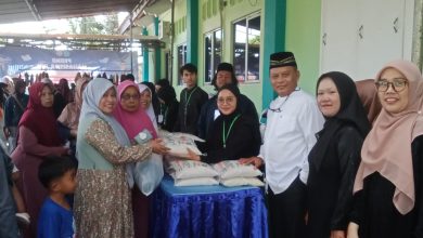 Panitia dan pimpinan STIEM Cilacap menyerahkan paket beras kepada warga dalam kegiatan bazar murah Ramadan di lingkungan kampus.