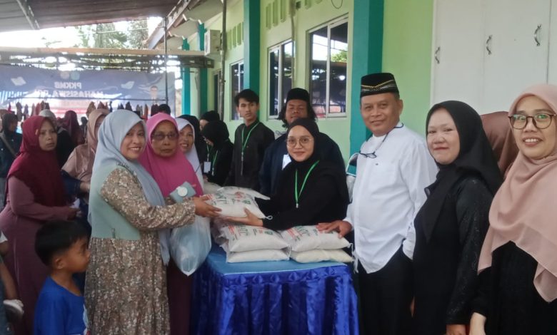 Panitia dan pimpinan STIEM Cilacap menyerahkan paket beras kepada warga dalam kegiatan bazar murah Ramadan di lingkungan kampus.