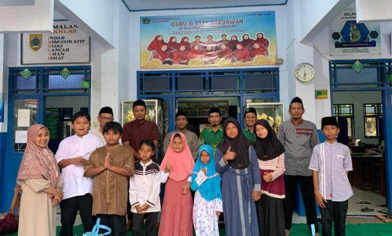 Guru dan siswa SD Muhammadiyah Kebagusan berfoto bersama penerima santunan dalam kegiatan pembagian bantuan sosial di lingkungan sekolah, Pemalang.