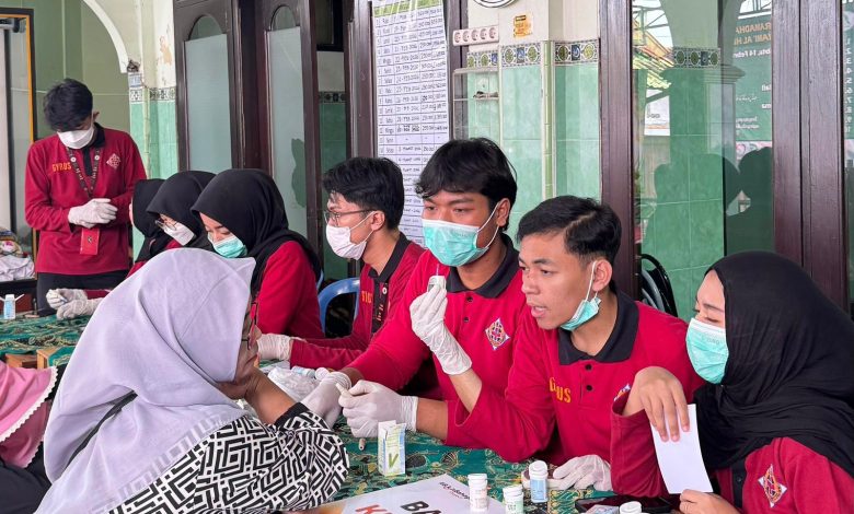 Mahasiswa TBM Gyrus FK UMS memberikan layanan pemeriksaan kesehatan gratis kepada warga dalam kegiatan GRAVITY 2026 di depan Masjid Jami’ Al-Hidayah, Surakarta.