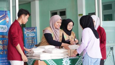 Petugas UMPWR menyerahkan paket beras zakat fitrah kepada penerima dalam kegiatan penyaluran zakat fitrah di lingkungan kampus.