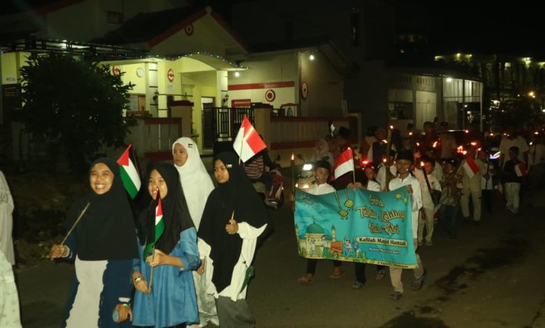 Peserta takbir keliling Blimbingrejo membawa bendera Indonesia dan Palestina pada malam Idulfitri