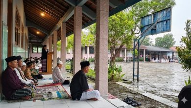 Jemaah salat Id Baleharjo Wonogiri berteduh di teras sekolah saat hujan tetap khusyuk mengikuti khutbah