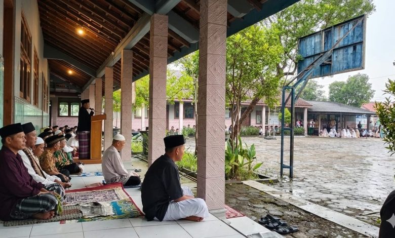 Jemaah salat Id Baleharjo Wonogiri berteduh di teras sekolah saat hujan tetap khusyuk mengikuti khutbah