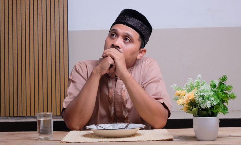 Ilustrasi seorang pria Muslim menahan lapar saat puasa Ramadan terkait pembahasan fidyah dan qadha puasa dalam Islam.