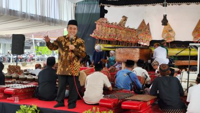 Seorang penceramah menyampaikan tausiah pada acara Halalbihalal di Masjid Ath Thalhah Mojorejo, Madiun, dengan latar pertunjukan wayang kulit dan gamelan.