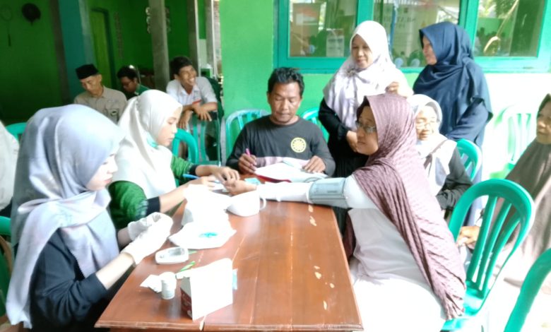 Petugas PKU Muhammadiyah Sampang melayani cek kesehatan gratis berupa pemeriksaan tensi darah dan gula darah bagi jamaah di Kesugihan, Cilacap.