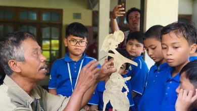 Perajin wayang kulit menunjukkan proses tatah sungging kepada murid SD Muhammadiyah PK Kottabarat Solo saat field trip budaya di Bantul.