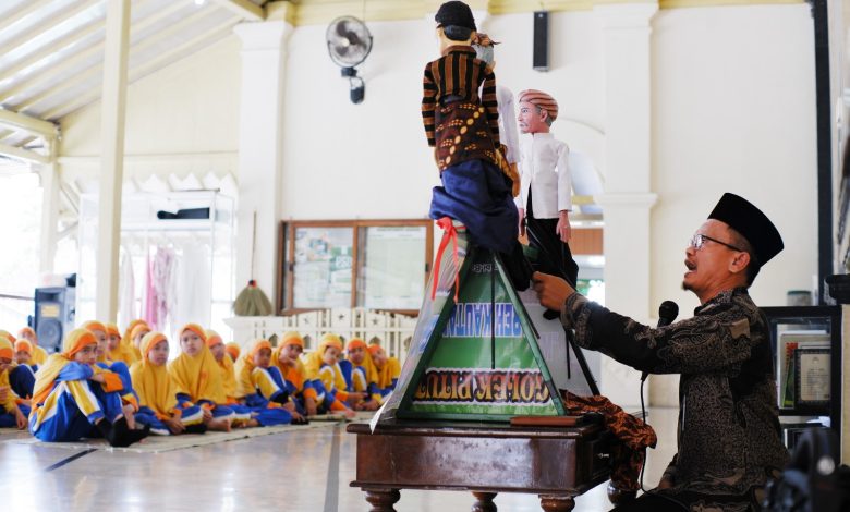 Dalang menyampaikan materi Kemuhammadiyahan melalui wayang golek kepada murid SD Muhammadiyah PK Kottabarat Solo saat outing class di Masjid Besar Ciptomulyo Pengging, Boyolali.