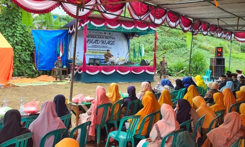 Ribuan jamaah wanita berhijab mendengarkan tausiyah Ikhwanushoffa dalam Kajian Ahad Pagi di PCM Wanayasa yang diadakan di bawah tenda oranye.