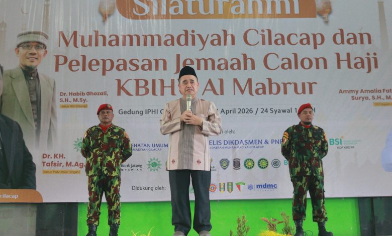 Dr. KH. Tafsir, M.Ag., Ketua PWM Jawa Tengah, sedang menyampaikan tausiah dengan mic di panggung, didampingi dua anggota KOKAM berseragam militer dan baret merah, di acara Silaturahmi Muhammadiyah Cilacap dan Pelepasan Jemaah Haji KBIHU Al Mabrur.