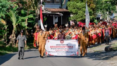Kirab pamitan siswa SMA Taruna Muhammadiyah Gunungpring angkatan 06 melintas di jalan kampung, dipimpin pembawa spanduk dan diiringi drum band pada Sabtu, 4 April 2026.