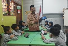 Guru SD Muhammadiyah 1 Solo mengajar pembelajaran Islam dengan bantuan AI dan tablet di dalam kelas.