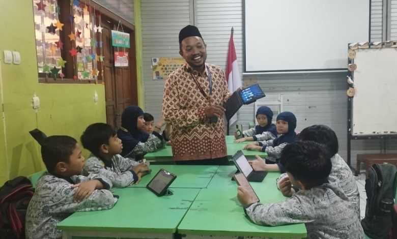 Guru SD Muhammadiyah 1 Solo mengajar pembelajaran Islam dengan bantuan AI dan tablet di dalam kelas.