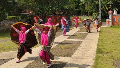 Anak-anak TK ABA Two berlari sambil memainkan kain di halaman sekolah saat mengikuti kegiatan belajar mengenal udara melalui hembusan angin di Kemranjen, Banyumas.