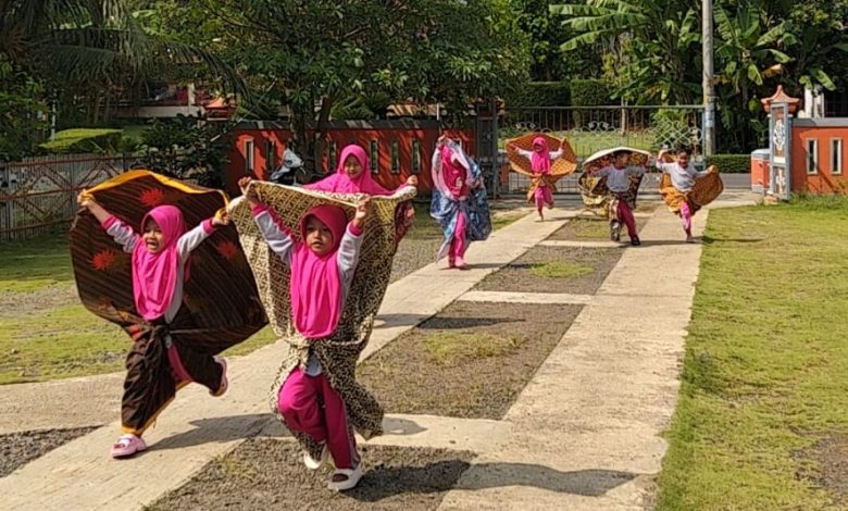 Anak-anak TK ABA Two berlari sambil memainkan kain di halaman sekolah saat mengikuti kegiatan belajar mengenal udara melalui hembusan angin di Kemranjen, Banyumas.