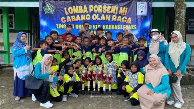 Siswa, guru, dan pendamping MI Muhammadiyah Singasari berfoto bersama sambil menunjukkan trofi juara setelah meraih sejumlah prestasi pada ajang Porseni Kecamatan Karanglewas di Desa Pangebatan.