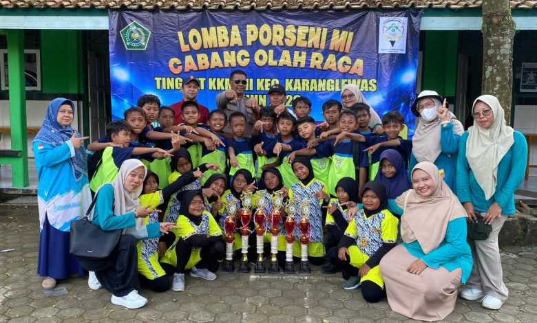 Siswa, guru, dan pendamping MI Muhammadiyah Singasari berfoto bersama sambil menunjukkan trofi juara setelah meraih sejumlah prestasi pada ajang Porseni Kecamatan Karanglewas di Desa Pangebatan.