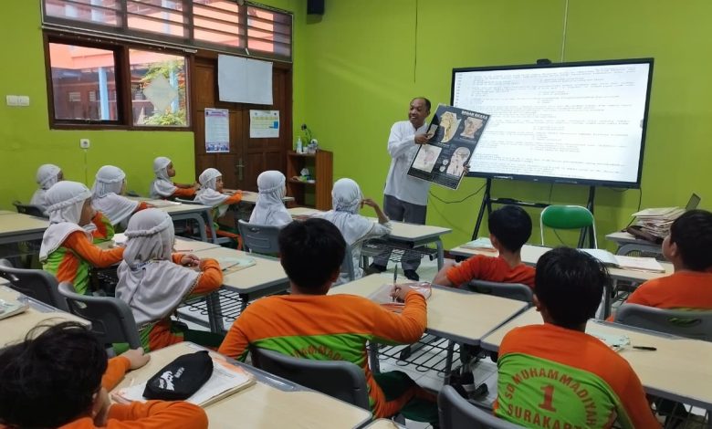Guru PAI mengajar siswa kelas III menggunakan layar sentuh Interactive Flat Panel (IFP) di SD Muhammadiyah 1 Ketelan Surakarta.