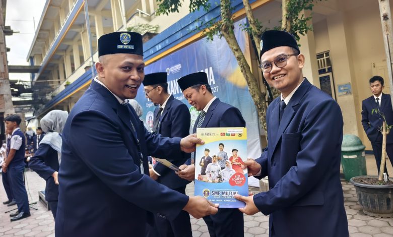 Kepala SMP Mutual Kota Magelang menyerahkan penghargaan kepada guru berprestasi setelah upacara bendera di sekolah.