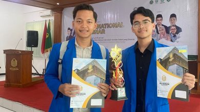 Dua mahasiswa PBA UMP memegang piala dan sertifikat juara lomba bahasa Arab internasional di ajang AFKAR 2026.