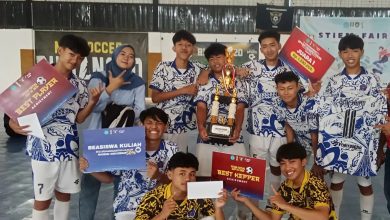 Tim futsal juara berfoto bersama sambil membawa trofi, piagam penghargaan, dan beasiswa kuliah pada Futsal Cup III 2026 STIEMC di Cilacap.