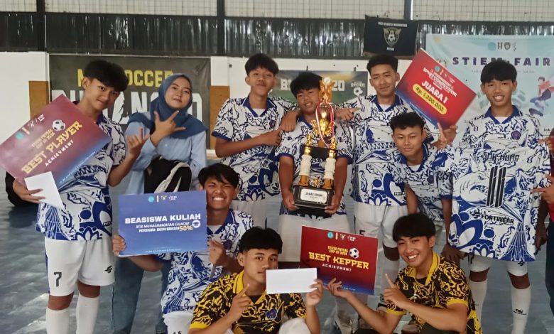 Tim futsal juara berfoto bersama sambil membawa trofi, piagam penghargaan, dan beasiswa kuliah pada Futsal Cup III 2026 STIEMC di Cilacap.
