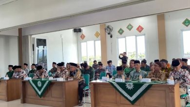 Sekelompok peserta pria mengenakan songkok hitam dan batik menghadiri acara di Kantor PDM Temanggung. Mereka duduk rapi di meja panjang di depan meja-meja berlakon warna hijau.