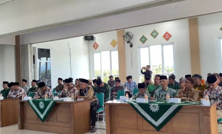 Sekelompok peserta pria mengenakan songkok hitam dan batik menghadiri acara di Kantor PDM Temanggung. Mereka duduk rapi di meja panjang di depan meja-meja berlakon warna hijau.