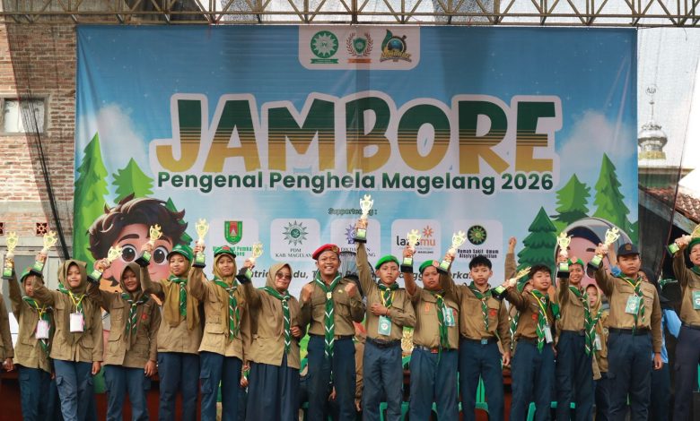 Para pemenang lomba Jambore Hizbul Wathan Magelang 2026 berpose di atas panggung sambil mengangkat trofi penghargaan di depan latar belakang spanduk acara.