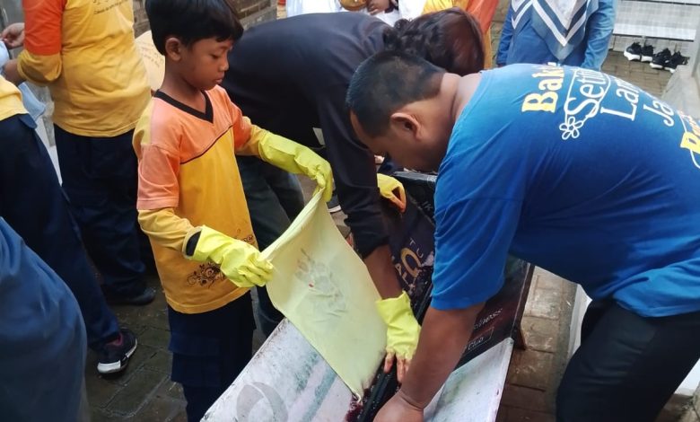 Siswa kelas 5 sedang praktik belajar membatik tahap pewarnaan atau mbabar menggunakan larutan warna di Pendopo Gemah Semilir.