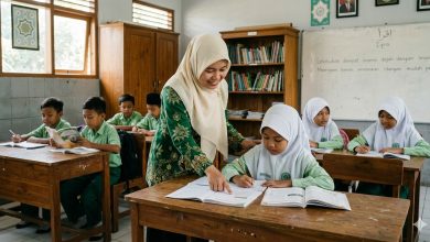 Guru wanita berhijab sedang membimbing siswa membaca dan menulis di dalam kelas pada momen Hari Pendidikan Nasional (Hardiknas).