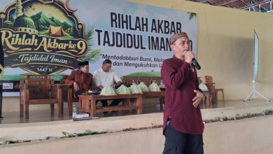 Suasana panggung utama Rihlah Akbar Tajdidul Iman ke-9 dengan latar belakang baliho besar dan pembicara sedang memberikan sambutan.