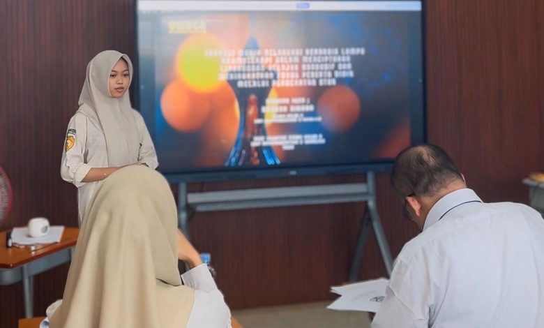 Siswa SMP Muhammadiyah 3 Sukolilo sedang mempresentasikan inovasi siswa SMP berupa lampu aroma terapi menggunakan layar digital di depan penguji ujian praktik.