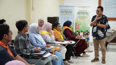 Peserta muda lintas iman sedang mendengarkan materi dalam pelatihan Akademi Eco Bhinneka Muhammadiyah yang disampaikan oleh seorang pemateri pria berbaju batik. Dua banner program terlihat di latar belakang.