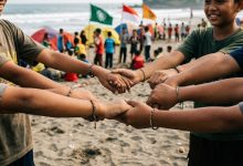 Detail tangan anak-anak panti asuhan Muhammadiyah saling berpegangan membentuk lingkaran di atas pasir Pantai Kembar Kebumen, simbol deklarasi Gerakan Rukun Sama Teman pada Jambore MCC ke-4 Jawa Tengah.