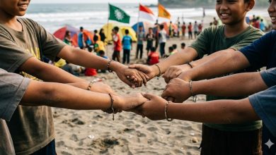 Detail tangan anak-anak panti asuhan Muhammadiyah saling berpegangan membentuk lingkaran di atas pasir Pantai Kembar Kebumen, simbol deklarasi Gerakan Rukun Sama Teman pada Jambore MCC ke-4 Jawa Tengah.