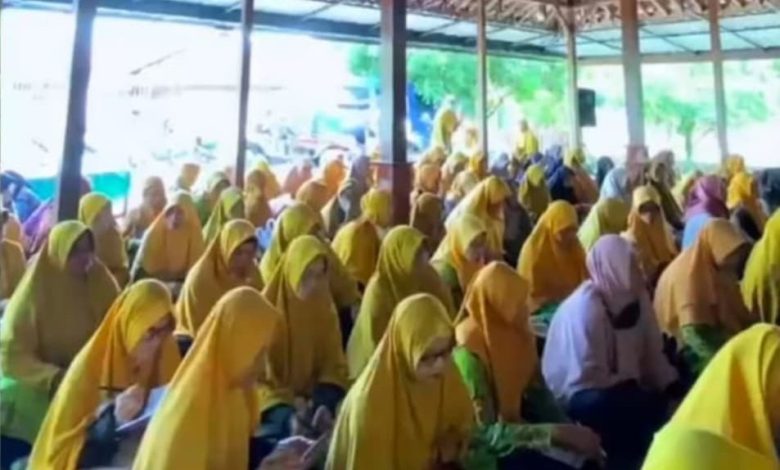 Sejumlah ibu-ibu anggota Aisyiyah dengan jilbab berwarna kuning sedang duduk khidmat mengikuti Pengajian Tarjih di sebuah pendopo.