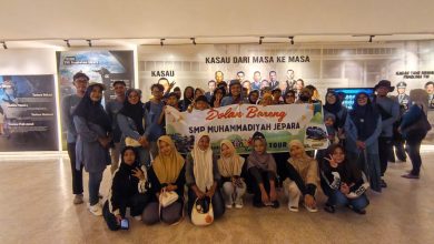 Rombongan besar siswa dan guru SMP Muhammadiyah Jepara berpose bersama di panggung terbuka Edutorium K.H. Ahmad Dahlan UMS. Mereka mengenakan seragam batik hijau dan putih berlogo Muhammadiyah, serta jilbab hijau. Di tengah, Prof. M. Din Syamsuddin memimpin doa, diapit oleh Rektor UMS Prof. Harun Joko Prayitno dan panitia yang memegang piala. Spanduk kecil di latar belakang bertuliskan 'EDUWISA JEPARA YOGYAKARTA - SMP MUHAMMADIYAH JEPARA'. Suasana panggung dihiasi tanaman dan bunga, dengan tangga Edutorium dan pepohonan hijau di latar belakang, di bawah langit biru yang cerah.