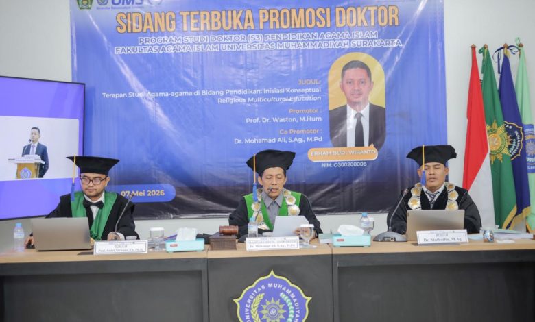 Sidang Terbuka Promosi Doktor (S3) Pendidikan Agama Islam (PAI) Fakultas Agama Islam (FAI) Universitas Muhammadiyah Surakarta (UMS) di panggung terbuka Edutorium K.H. Ahmad Dahlan UMS. Di tengah panggung, di depan spanduk besar bertuliskan 'SIDANG TERBUKA PROMOSI DOKTOR...', Erham Budi Wiranto (Doktor PAI ke-66, memegang toga dan dokumen lulus sangat memuaskan) berdiri diapit oleh promotor Prof. Dr. Waston (ketiga dari kiri), ko-promotor Dr. Mohamad Ali (kedua dari kiri), dan tim panitia. Mereka mengenakan seragam batik hijau dan putih berlogo Muhammadiyah. Di latar depan, ratusan siswa SD/MI Muhammadiyah/Aisyiyah yang duduk khidmat, juga dalam seragam ihram jilbab putih, mengikuti doa. Latar belakang menunjukkan tangga Edutorium, pepohonan hijau, dan pemandangan modern di bawah langit biru yang cerah. Suasana khidmat, bangga, dan penuh kebersamaan yang menggembirakan.