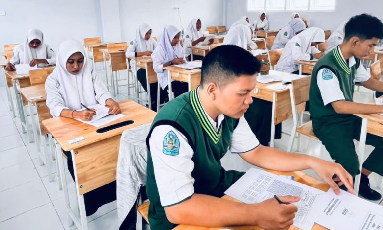 Foto suasana outdoor acara peresmian Jurusan Manajemen Perkantoran di SMK Muhammadiyah Aceh. Di panggung, tampak spanduk peresmian berwarna merah-putih-kuning. Banyak tamu undangan duduk di bawah tenda dengan dekorasi senada, dihiasi dedaunan pohon mangga di latar depan. Seorang kameramen sedang mendokumentasikan acara.