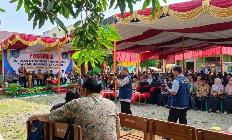 Suasana peresmian Jurusan Manajemen Perkantoran SMK Muhammadiyah Aceh di area terbuka dengan tenda merah kuning, spanduk besar di panggung, dan tamu undangan yang hadir.